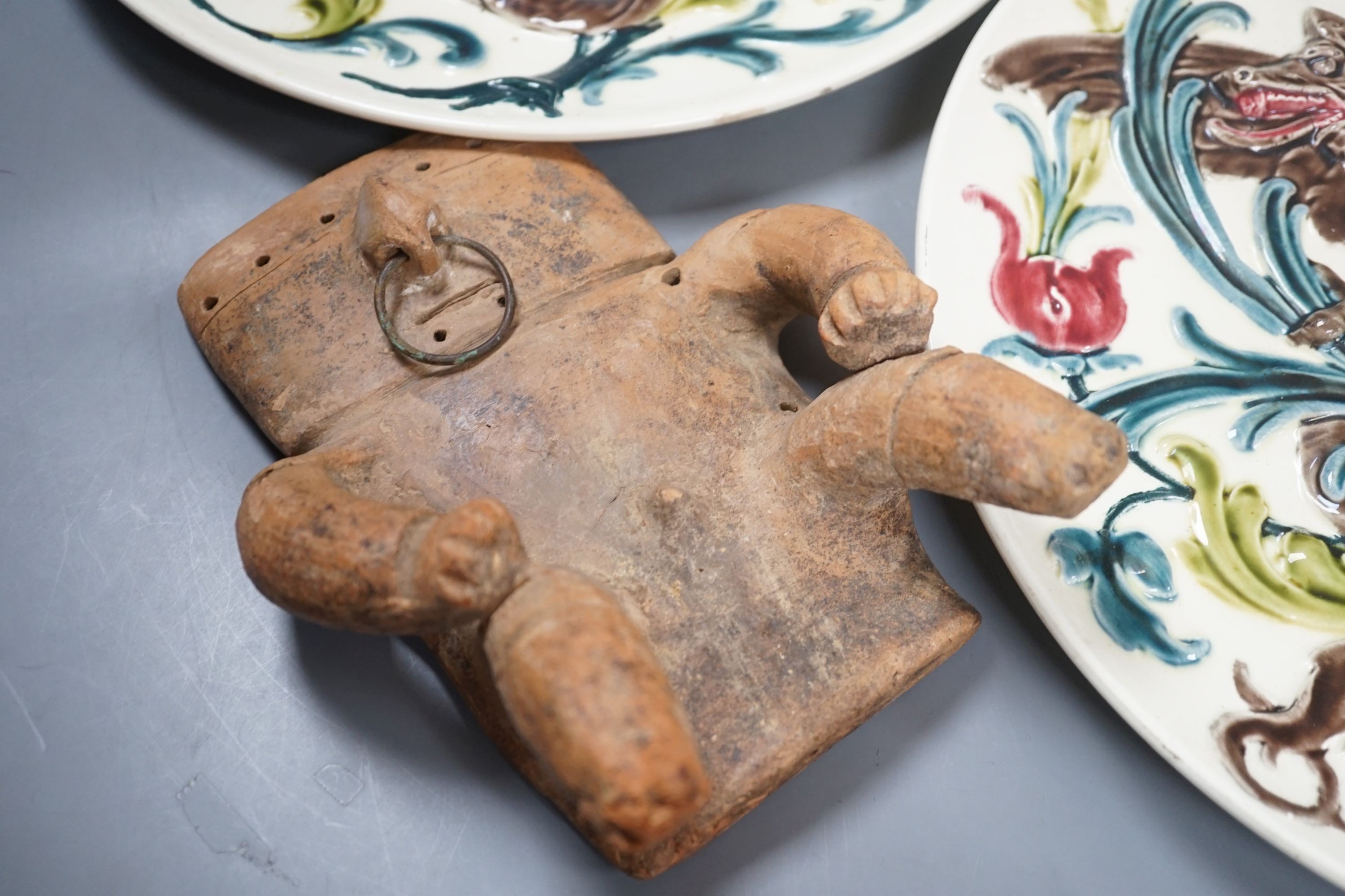 A pair of French pottery dragon & shield dishes, a Queen Victoria Diamond Jubilee teapot and a Quimbaya Culture clay figure, dishes 32 cms diameter.